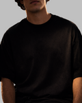 Person wearing a plain black t-shirt against a gray background